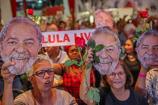 Supporters hold up masks of former president Lula during rally that called for his release from prison