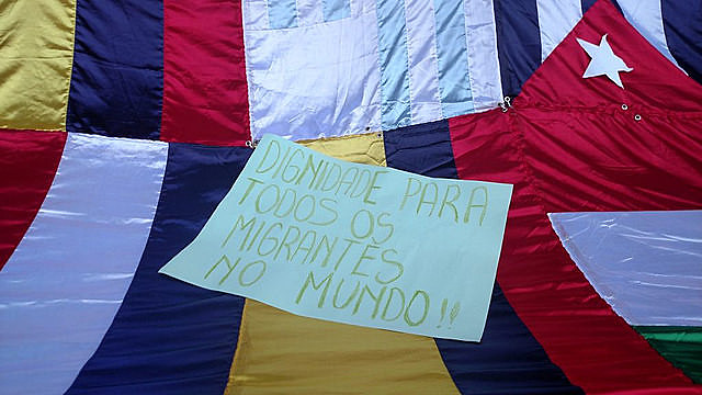 Cartel en la Marcha de los Inmigrantes de 2016 pide dignidad para los migrantes en todo el mundo