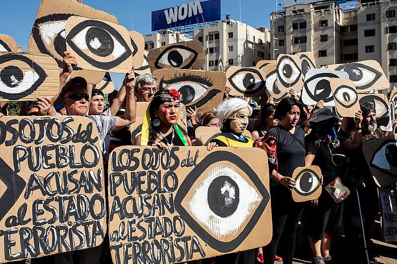 Chilenos exibem cartazes em referência aos projéteis que atingem os olhos dos manifestantes durante um protesto em dezembro