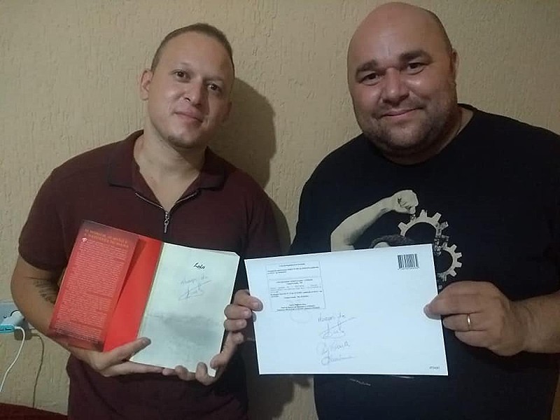 Antonio Elandio (dir.) posa com o  diploma ao lado do primo