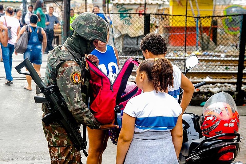 Estudantes uniformizados são revistados por agentes das forças de segurança