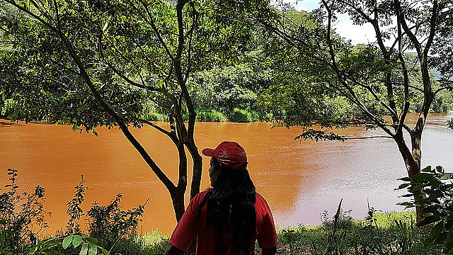 Angela Fernandes Costa, habitante de la región, observa el río contaminado tras el derrame de relaves