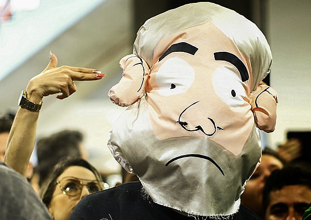 Una mujer escenifica una “ejecución” de un muñeco que hace referencia al ex presidente Lula