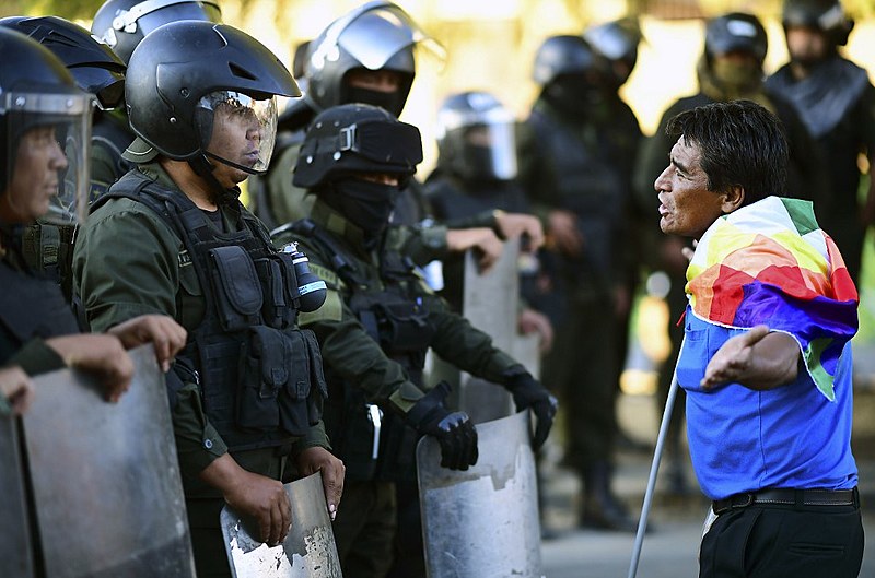 A supporter of Bolivian ex-President Evo Morales faces riot police during a demonstration in Cochabamba, on November 18, 2019