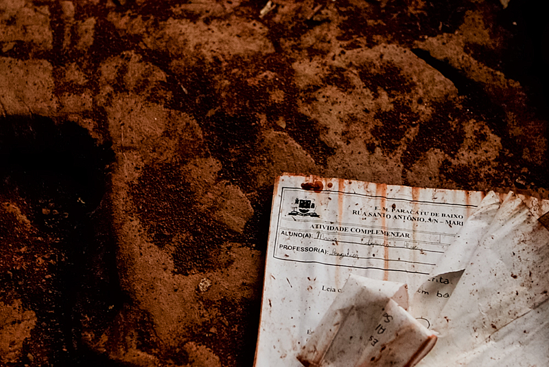 Escola destruída pela lama na comunidade de Paracatu de Baixo, em Mariana. Cinco anos após o crime, os livros, mesas, carteiras e materiais escolares permanecem em meio à destruição.