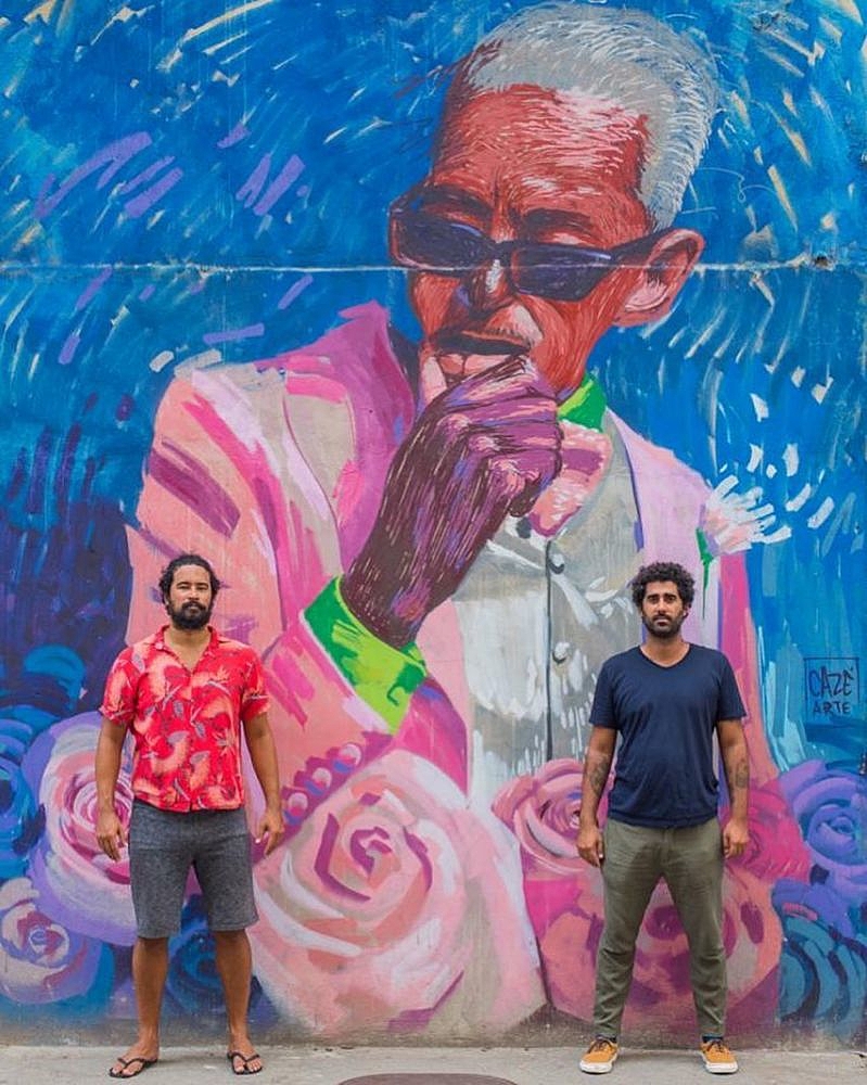 Pedro e Cazé em frente ao grafite do músico Cartola