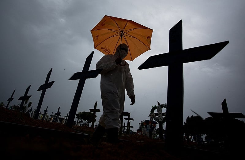 Trabalhador passa por túmulos das vítimas de covid-19 no cemitério Nossa Senhora Aparecida, em Manaus, nesta quinta (25); Brasil ultrapassou 250.000 mortes pela doença
