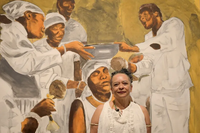 foto de ana maria gonçalves com uma pintura atrás