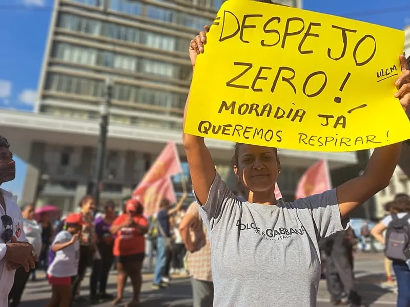homem segura cartaz com os dizeres despejo zero, moradia já