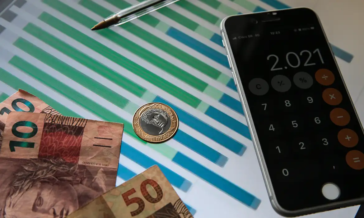 Moedas e cédulas de reais e calculadora