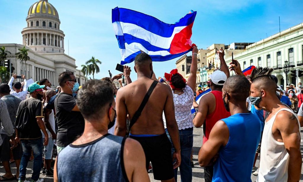 Cubanos em frente à sede do Congresso, em Havana