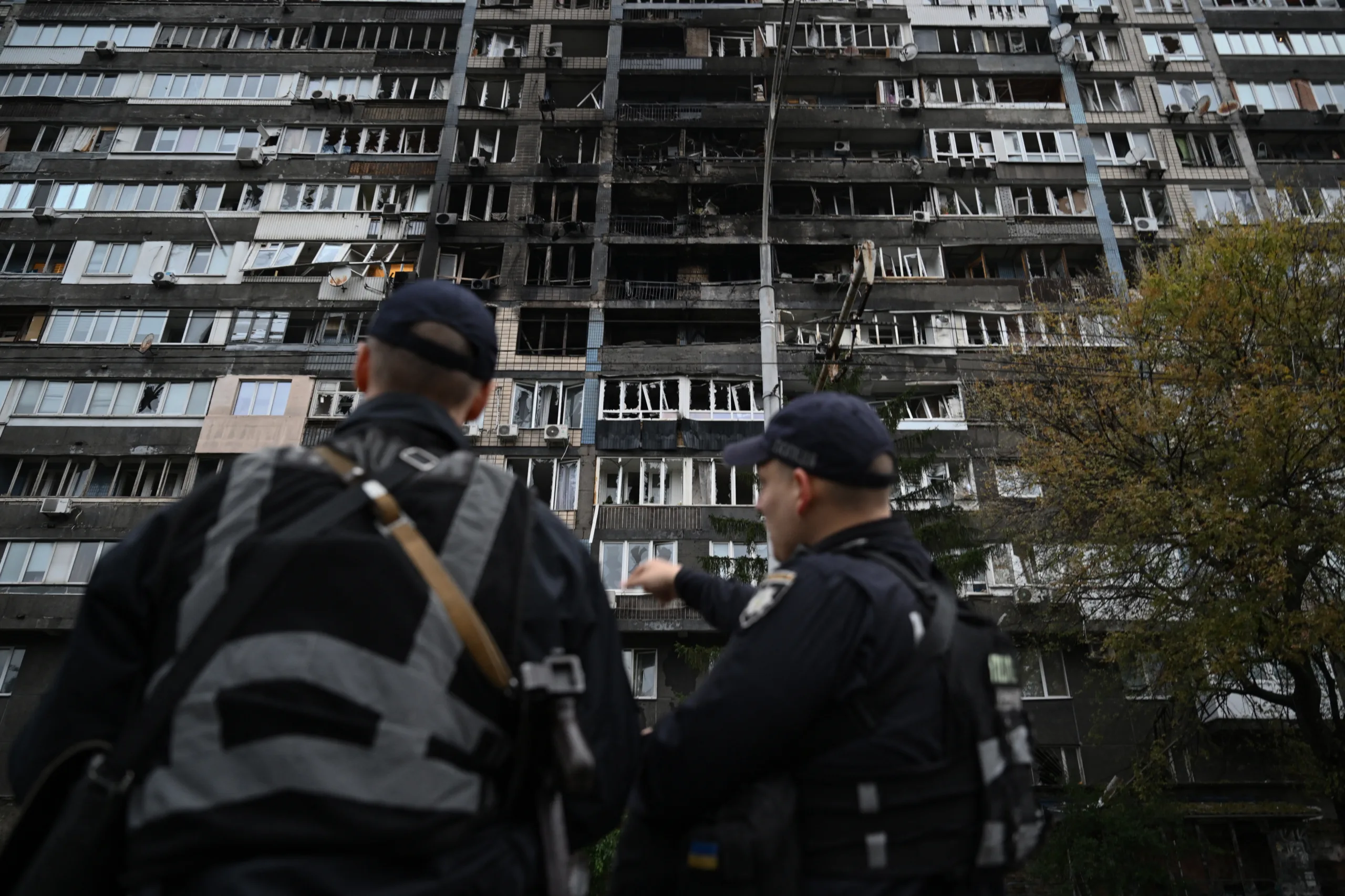 Policiais ucranianos em frente a um prédio residencial, danificado após ataques massivos de mísseis russos à capital ucraniana, Kiev, em 10 de outubro de 2025