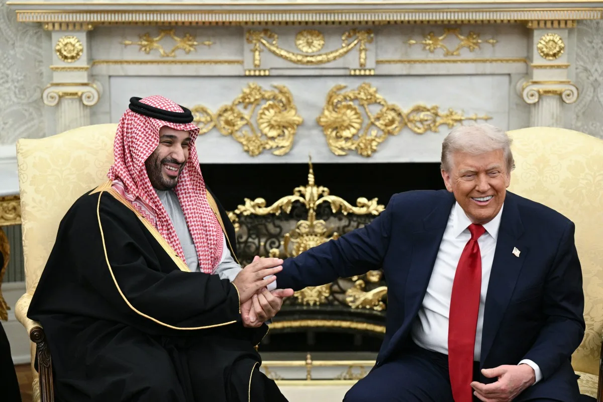 US President Donald Trump jokes about hand shakes and fist pumps with Crown Prince and Prime Minister of the Kingdom of Saudi Arabia Mohammed bin Salman during a meeting in the Oval Office of the White House in Washington, DC on November 18, 2025. Saudi Crown Prince Mohammed bin Salman arrived at the White House to fanfare and a jet flyover Tuesday, in his first visit to the United States since the 2018 murder of journalist Jamal Khashoggi. (Photo by Brendan SMIALOWSKI / AFP)