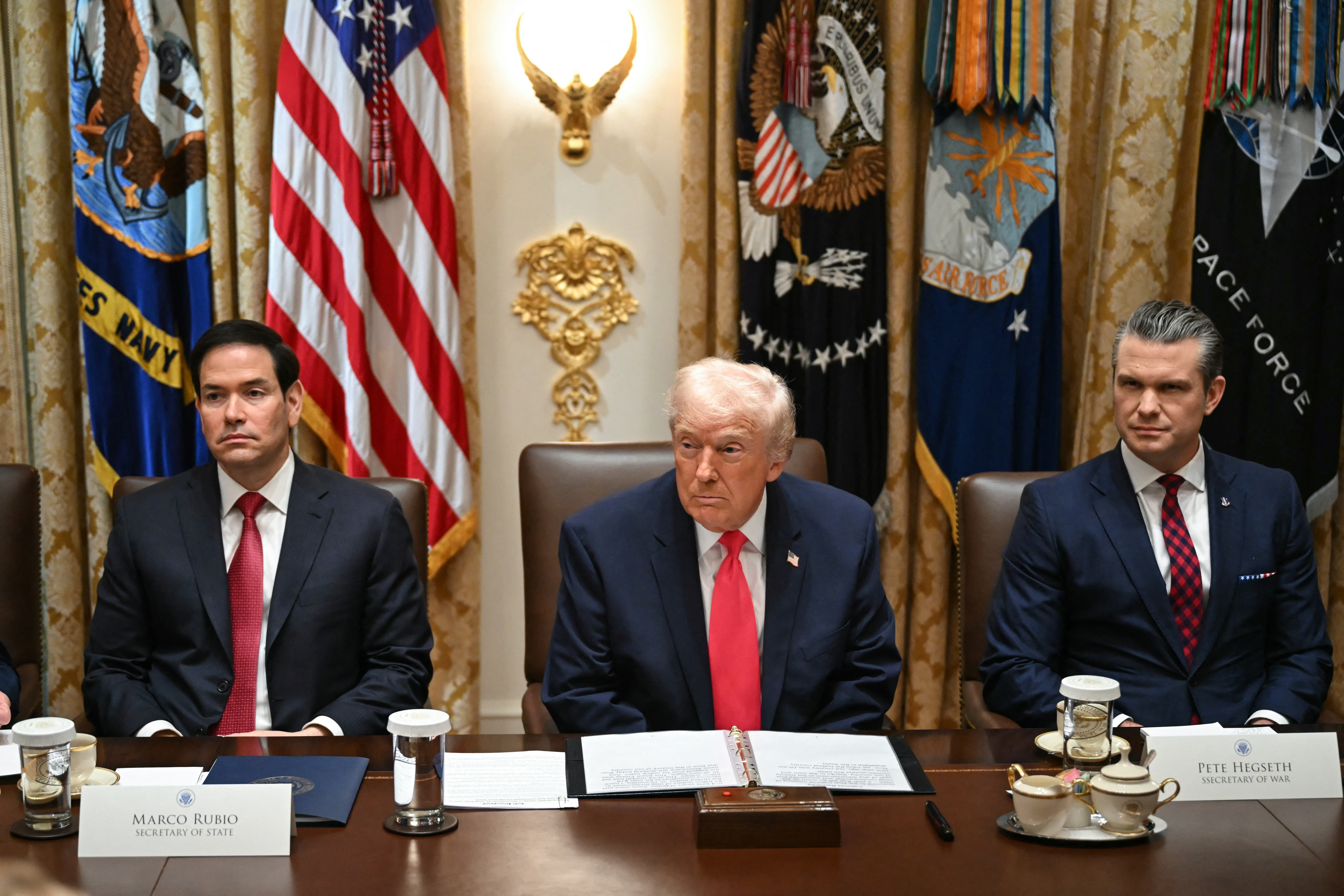Presidente dos EUA, Donald Trump, junto ao secretário de Estado, Marco Rubio (esq.), e do secretário de Guerra, Pete Hegseth, na Sala de Reuniões do Gabinete da Casa Branca, em Washington, DC - 2 de dezembro de 2025.
