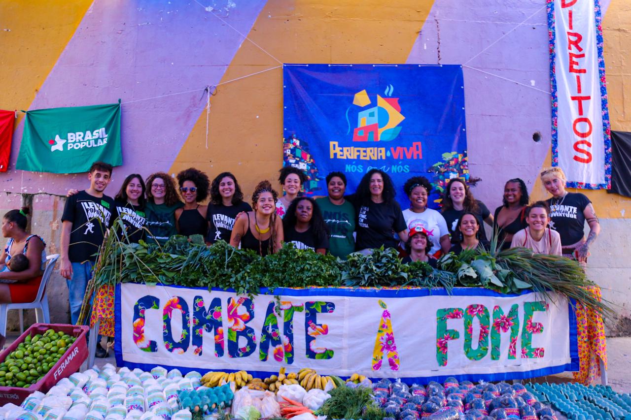 mesa com alimentos de hortifrúti e faixa escrita combate à fome