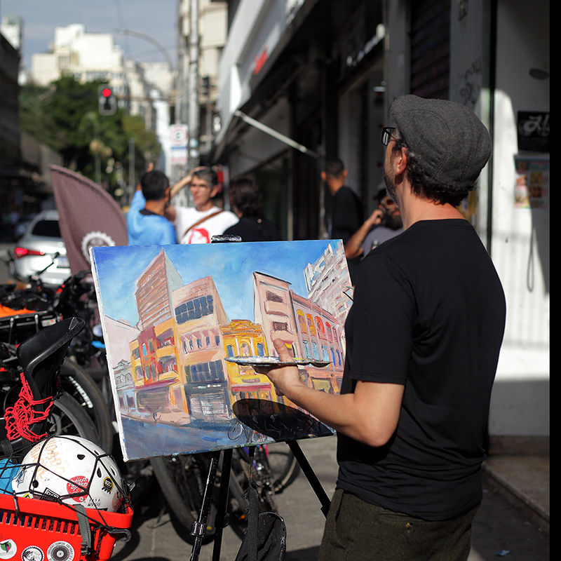 Artista Marcelo Siqueira pinta tela durante primeiro BiciArte realizado em dezembro de 2024 na Rua do Arouche