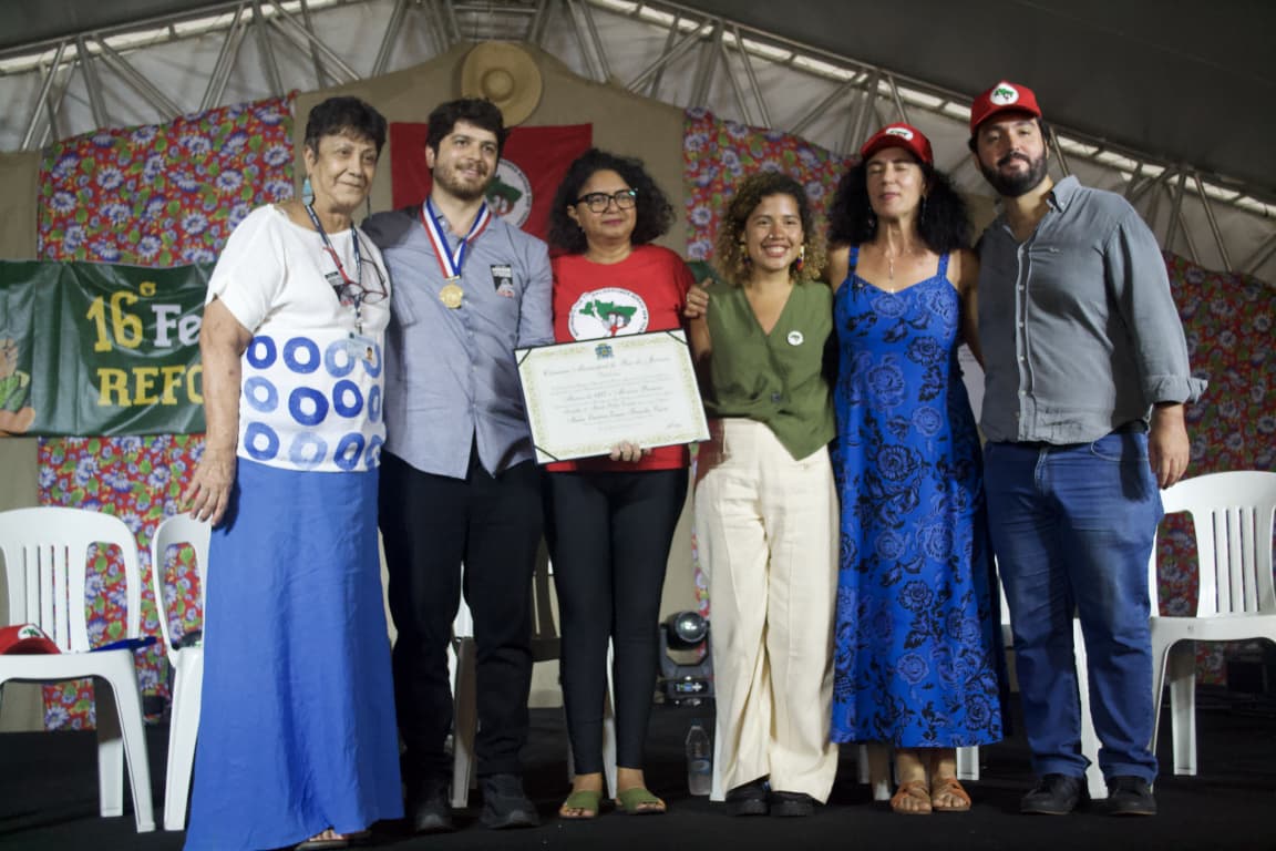 Foto da entrega da placa em homenagem à Eunice Paiva recebida pelo seu neto Chico Paiva