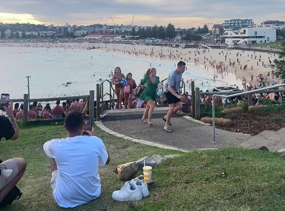 Banhistas correm desesperados na praia de Bondi, em Sidney, Austrália, após início de tiroteio