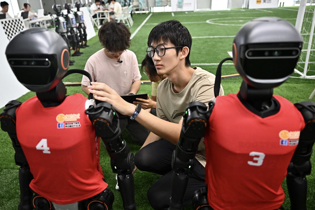 Estudantes chineses montam robôs humanoides durante os Jogos Mundiais de Robôs Humanoides em Pequim, no dia 4 de agosto de 2025.