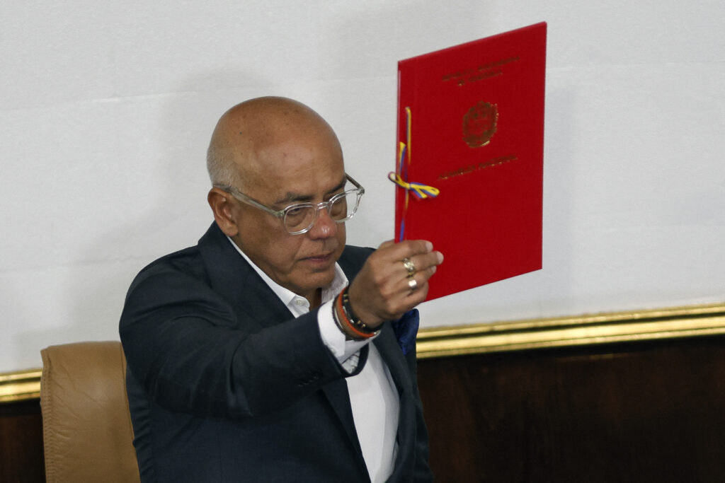 O presidente da Assembleia Nacional, Jorge Rodríguez, mostra o projeto de lei de anistia proposto pela presidenta interina da Venezuela, Delcy Rodríguez, durante a sessão para a primeira votação