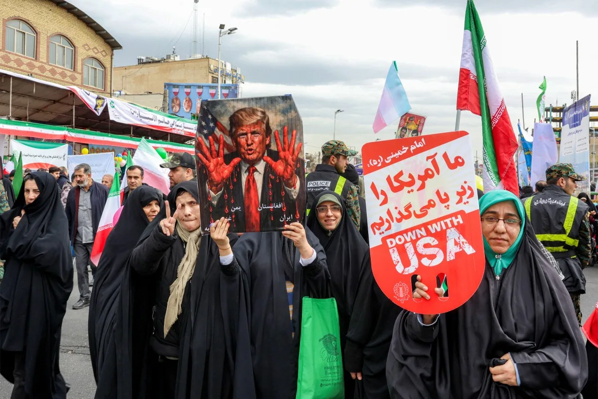 Cartaz representando o presidente dos EUA, Donald Trump, com as mãos ensanguentadas em Teerã, em 11 de fevereiro de 2026, durante uma manifestação que marca o 47º aniversário da Revolução Islâmica de 1979
