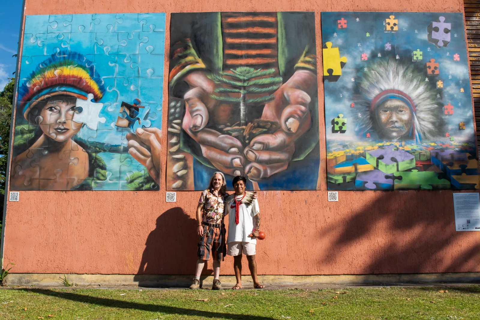 Artista Alessandro Muller e Cacique Kaingang Maurício Salvador junto às três pinturas na Vila Joaquina