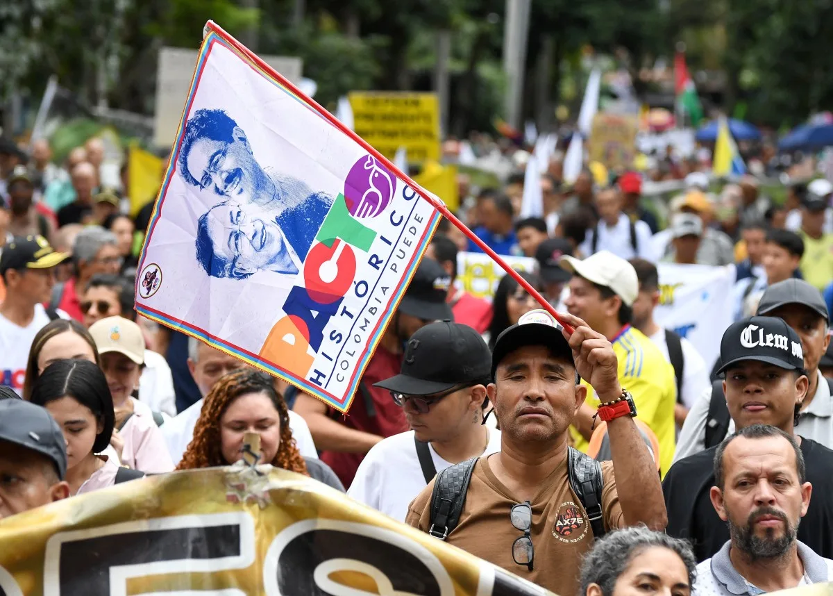 Manifestante exibe bandeira com o presidente da Colômbia, Gustavo Petro, e o candidato presidencial do Pacto Histórico, Iván Cepeda, durante ato em Medellín, em 19 de fevereiro de 2026