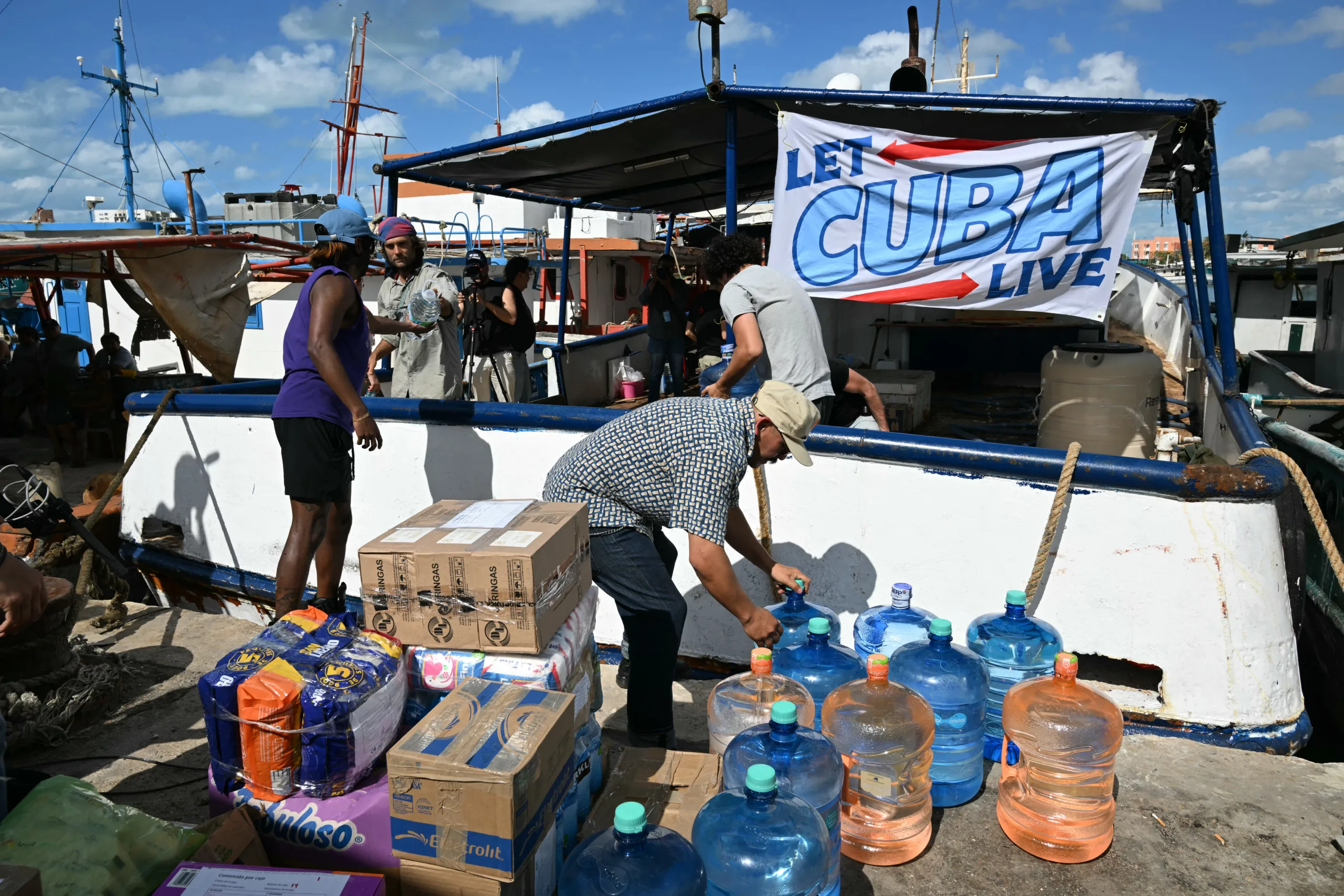 Ativistas carregam grandes galões de água a serem levados em ajuda humanitária a Cuba