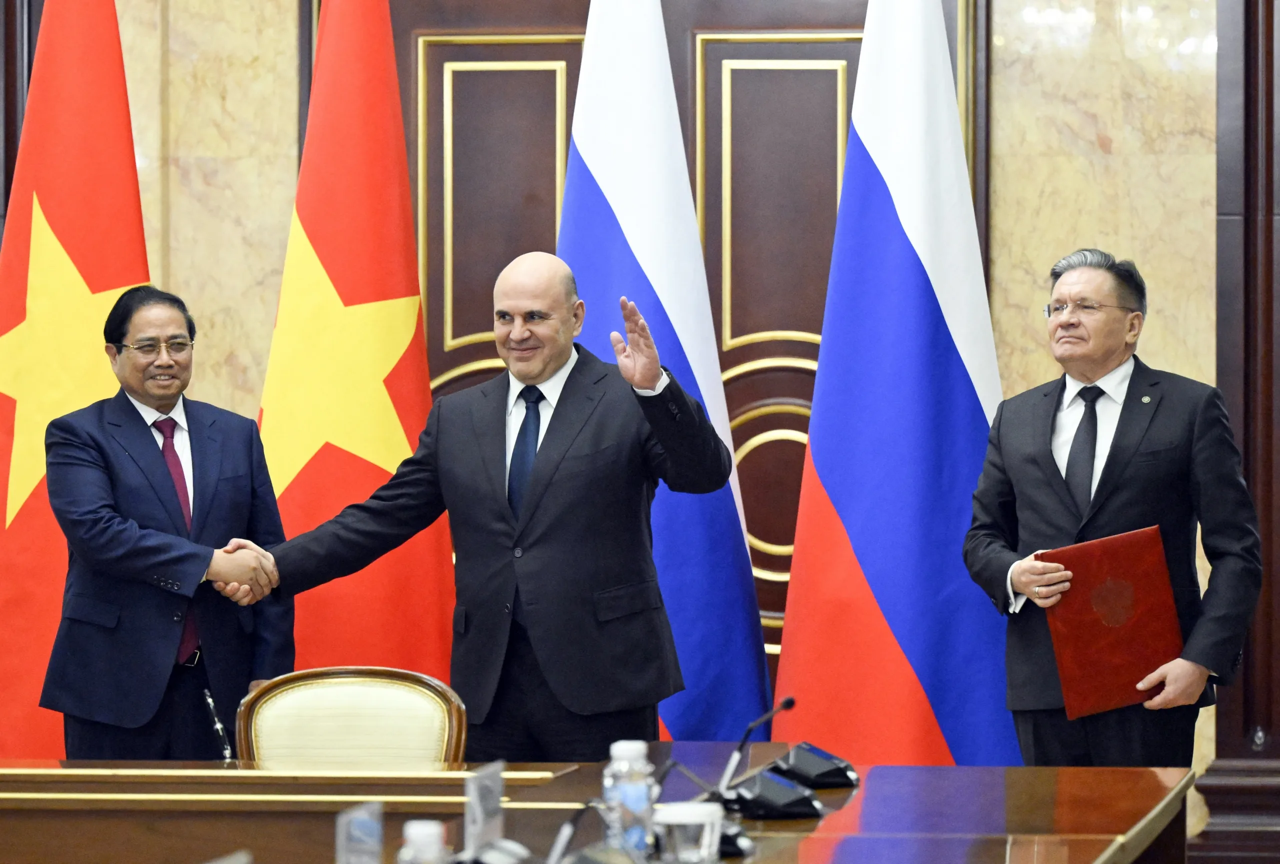 O primeiro-ministro russo Mikhail Mishustin (centro), o primeiro-ministro vietnamita Pham Minh Chinh (esquerda) e o diretor-geral da Corporação Estatal de Energia Atômica da Rússia, Rosatom, Alexei Likhachev (direita), participam de uma cerimônia de assinatura de um acordo de cooperação para a construção de uma usina nuclear no território do Vietnã, em Moscou, em 23 de março de 2026.