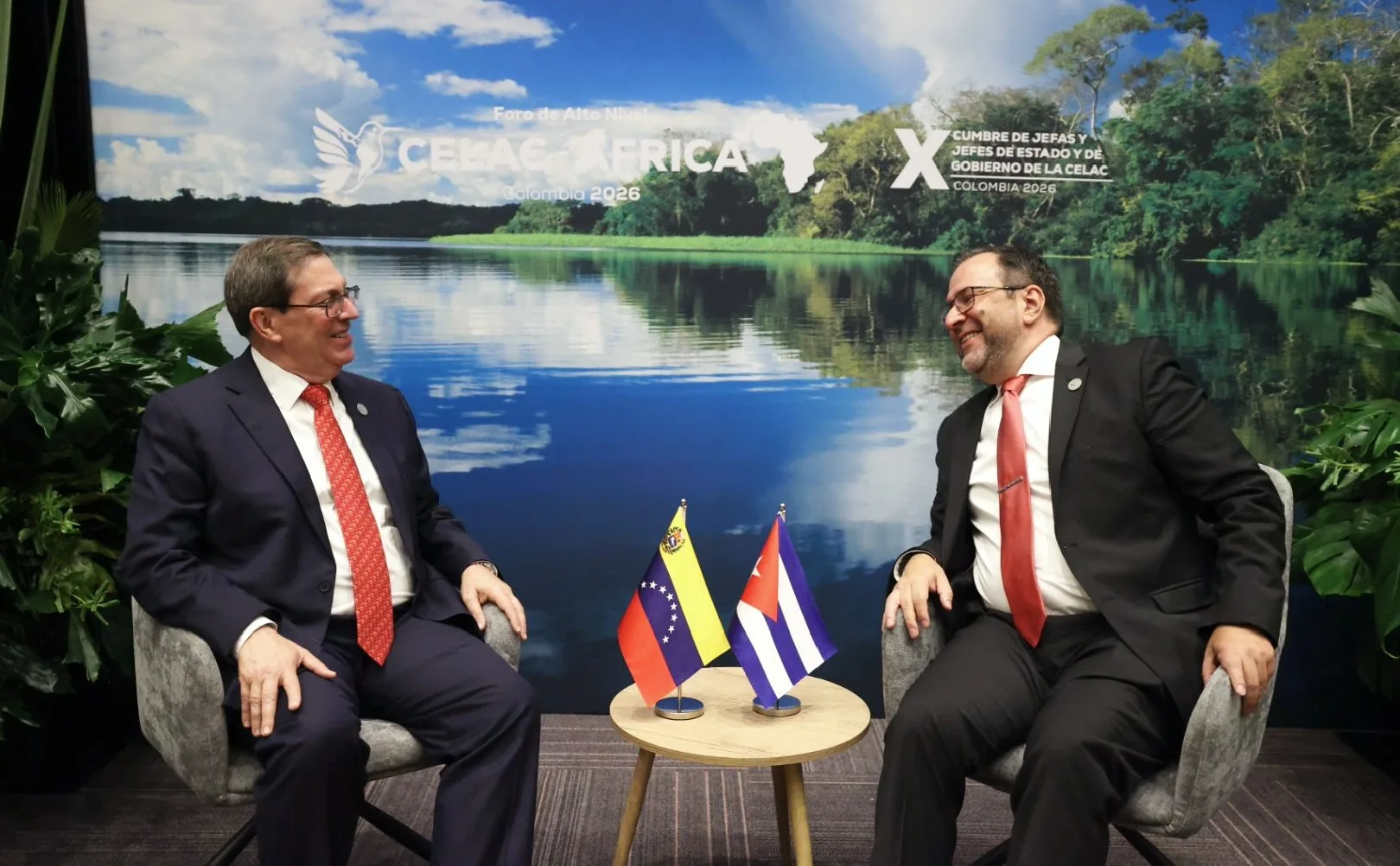 Os chanceleres Bruno Rodríguez (Cuba) e Yván Gil (Venezuela) sentados em sala oficial de reuniões, vestidos com terno e gravata