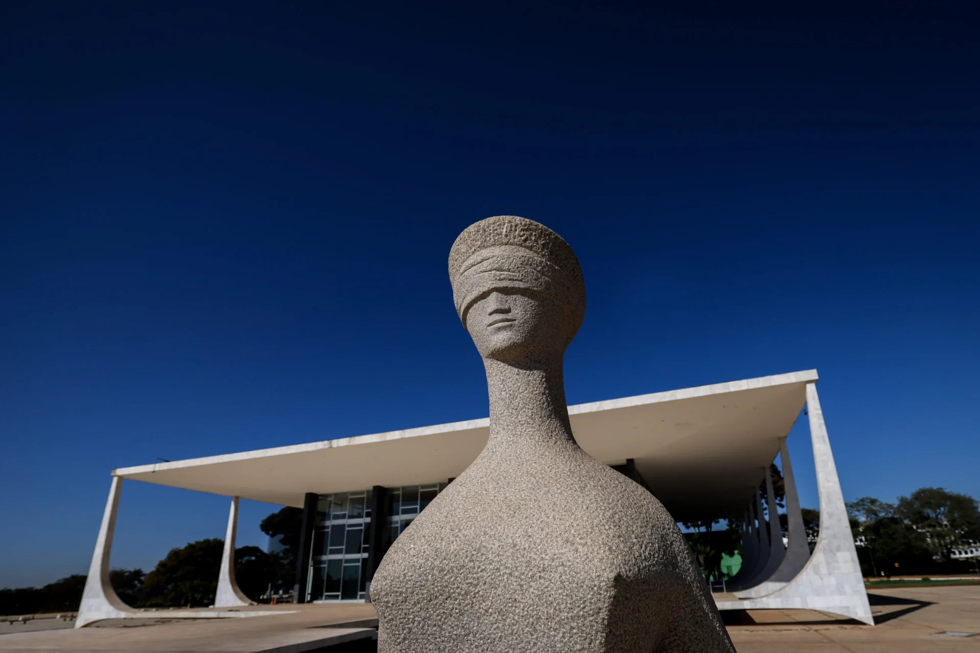 A imagem mostra a fachada do Supremo Tribunal Federal com a escultura da Justiça em primeiro plano e o prédio ao fundo. No contexto do artigo exclusivo, o elemento simboliza o centro das decisões institucionais envolvidas na proposta de reforma do Judiciário