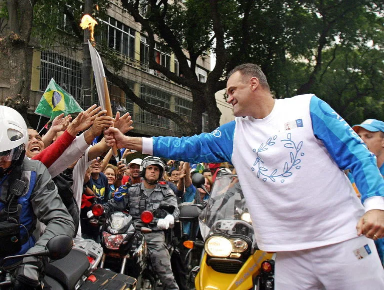 Oscar Schmidt conduz a tocha olímpica durante cerimônia pelas ruas do Rio de Janeiro, em 13 de junho de 2004