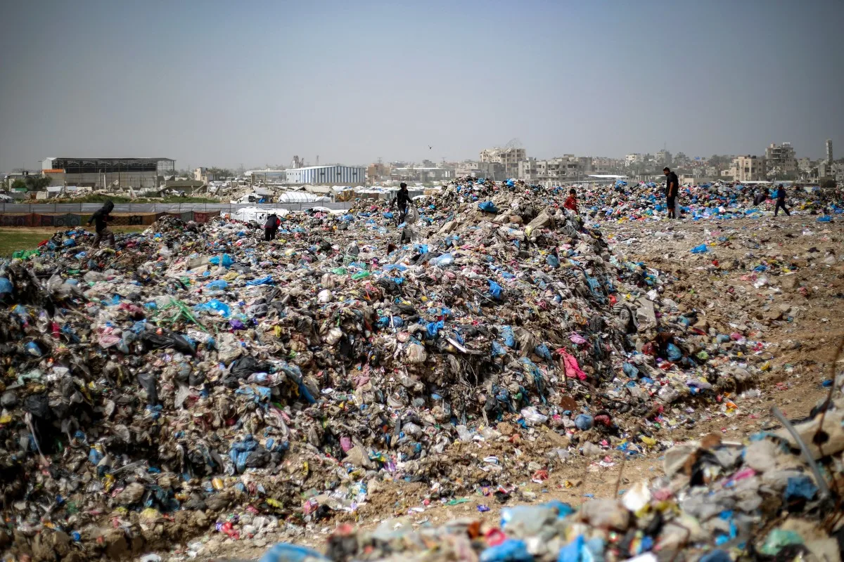 Crianças buscam materiais em lixão no campo de refugiados de Bureij, no centro da Faixa de Gaza, em 4 de abril de 2026.