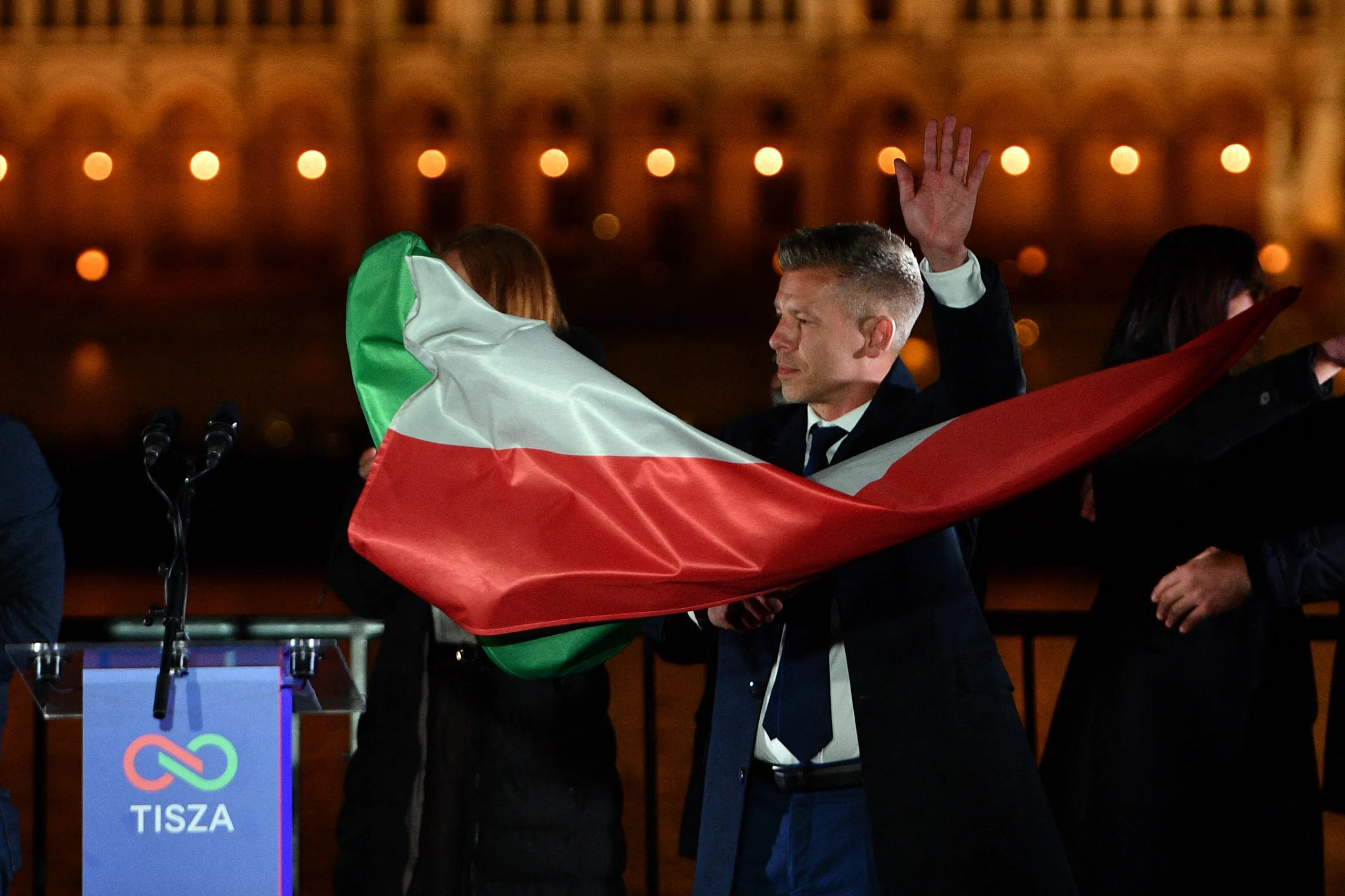 Peter Magyar, líder do partido Tisza, acena com a bandeira nacional durante as comemorações na festa da noite eleitoral em Budapeste, após as eleições gerais na Hungria, em 12 de abril de 2026.