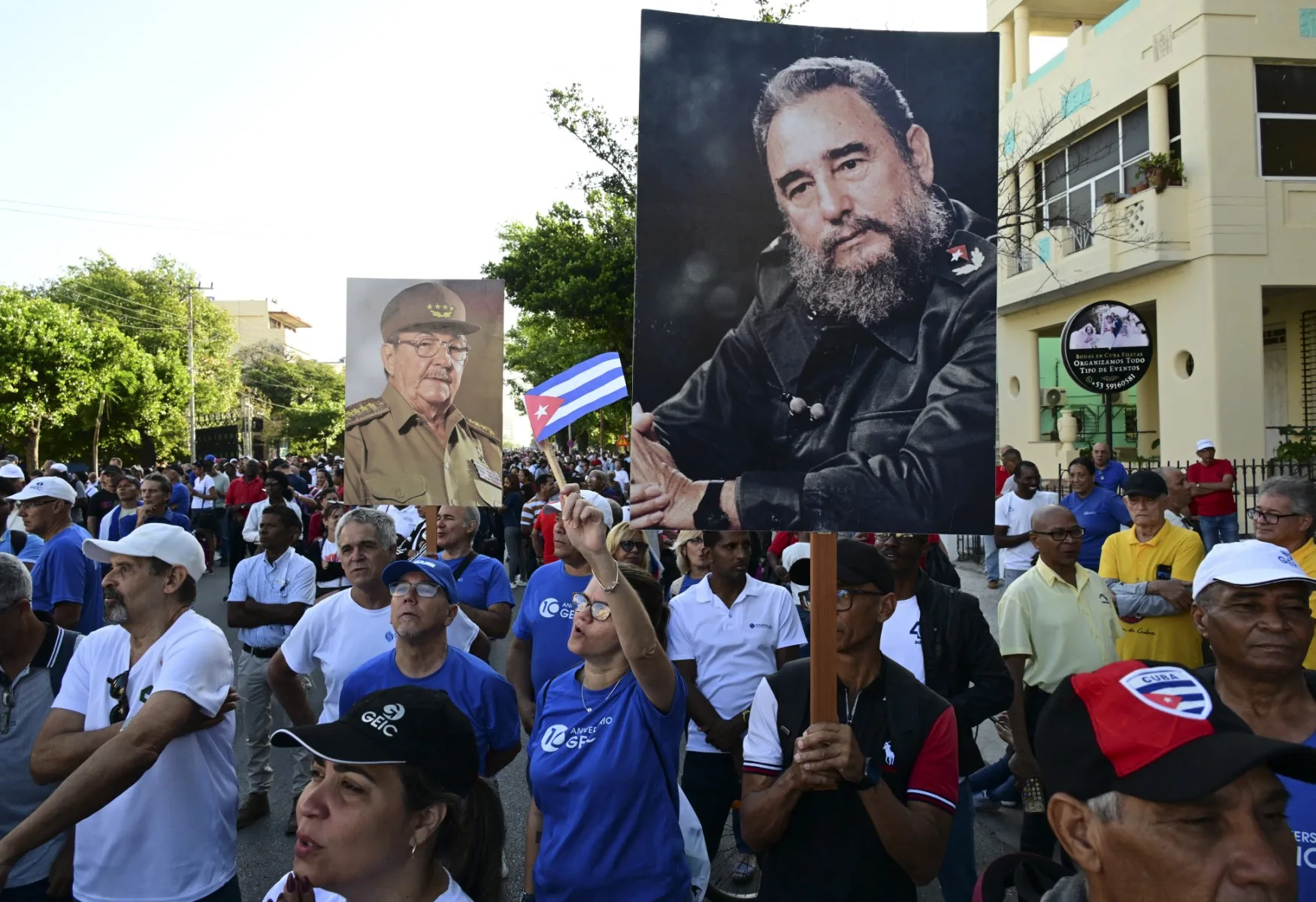 Pessoas seguram fotos do falecido líder Fidel Castro e de seu irmão, o ex-presidente Raúl Castro, durante as comemorações que marcam a vitória no 65º aniversário da invasão da Baía dos Porcos