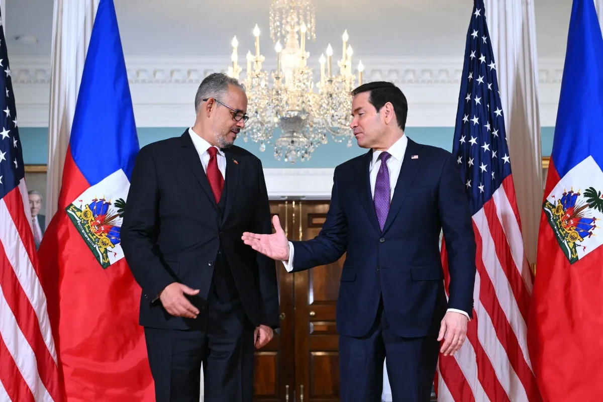 O secretário de Estado dos EUA, Marco Rubio (à direita), cumprimenta o primeiro-ministro haitiano, Alix Didier Fils-Aime, durante reunião no Departamento de Estado, em Washington, D.C., em 21 de abril de 2026.