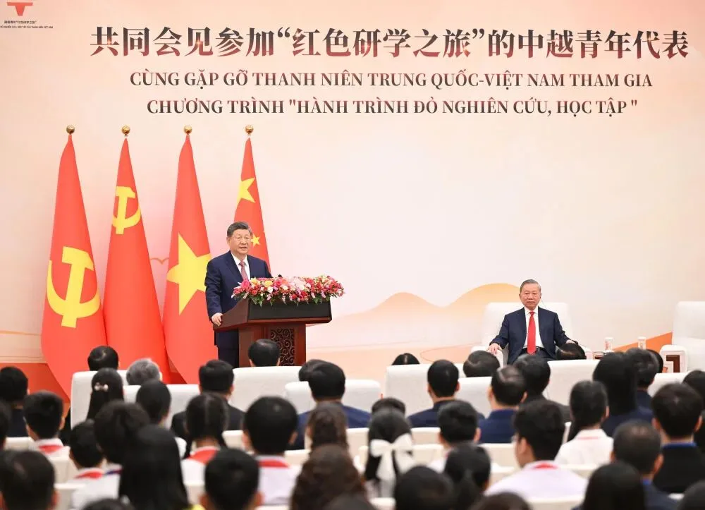 Secretário-geral do Comitê Central do PCCh e presidente da China, Xi Jinping, junto a To Lam, secretário-geral do Partido Comunista do Vietnã e presidente do Vietnã, em reunião no Grande Salão do Povo, em Pequim, com representantes de jovens da China e do Vietnã que participam do programa "Viagem de Estudos Vermelha".