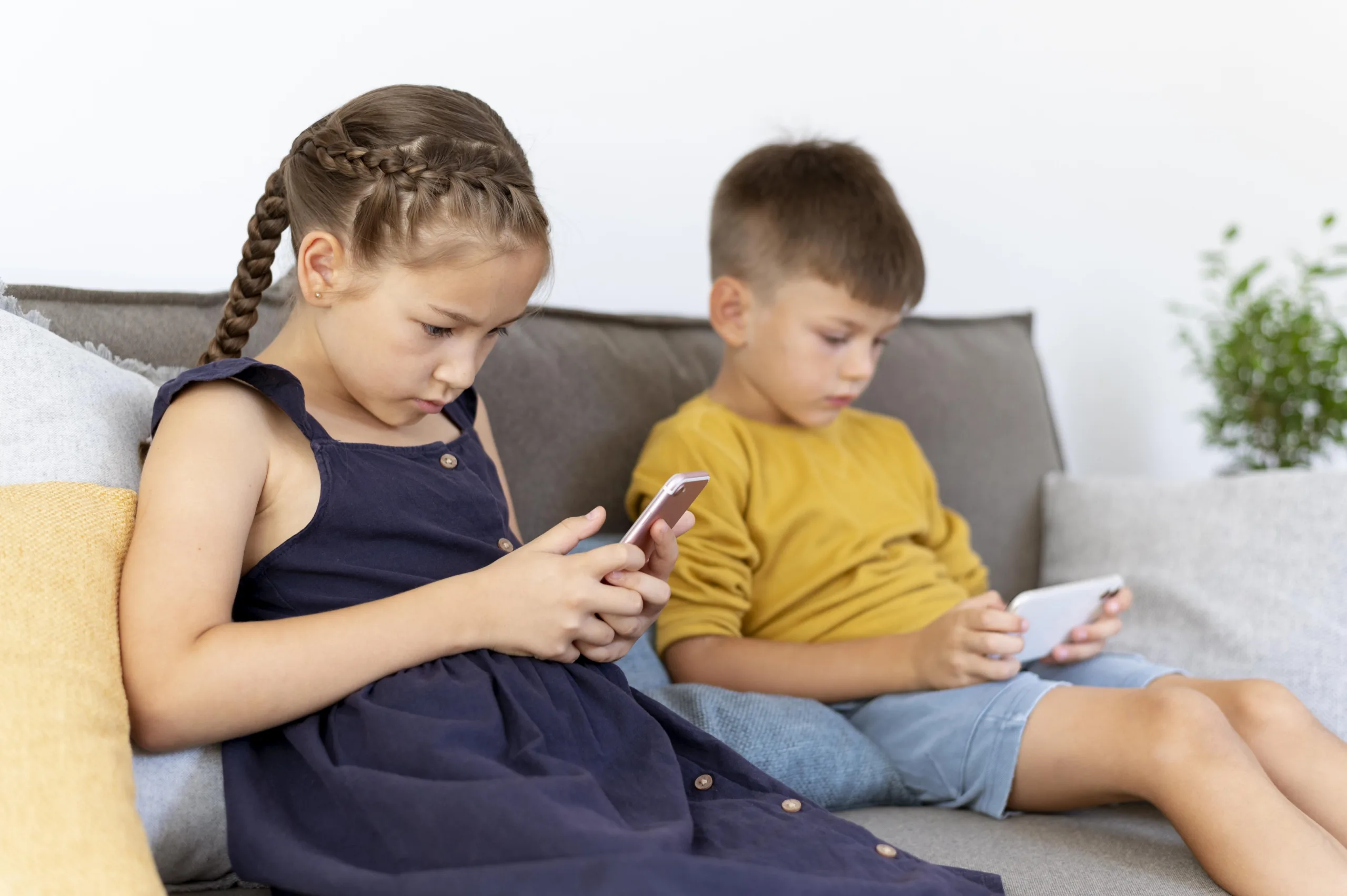 crianças entretidas com tela de celular e tablet