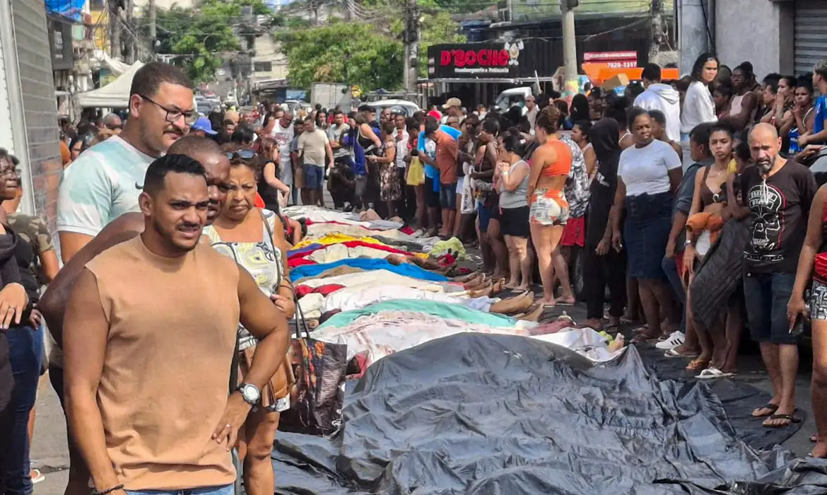 Dezenas de corpos são trazidos por moradores para a Praça São Lucas, na Penha, zona norte do Rio de Janeiro, após ação policial da Operação Contenção. Foto: Eusébio Gomes/TV Brasil© Eusébio Gomes/TV Brasil Versão em áudio