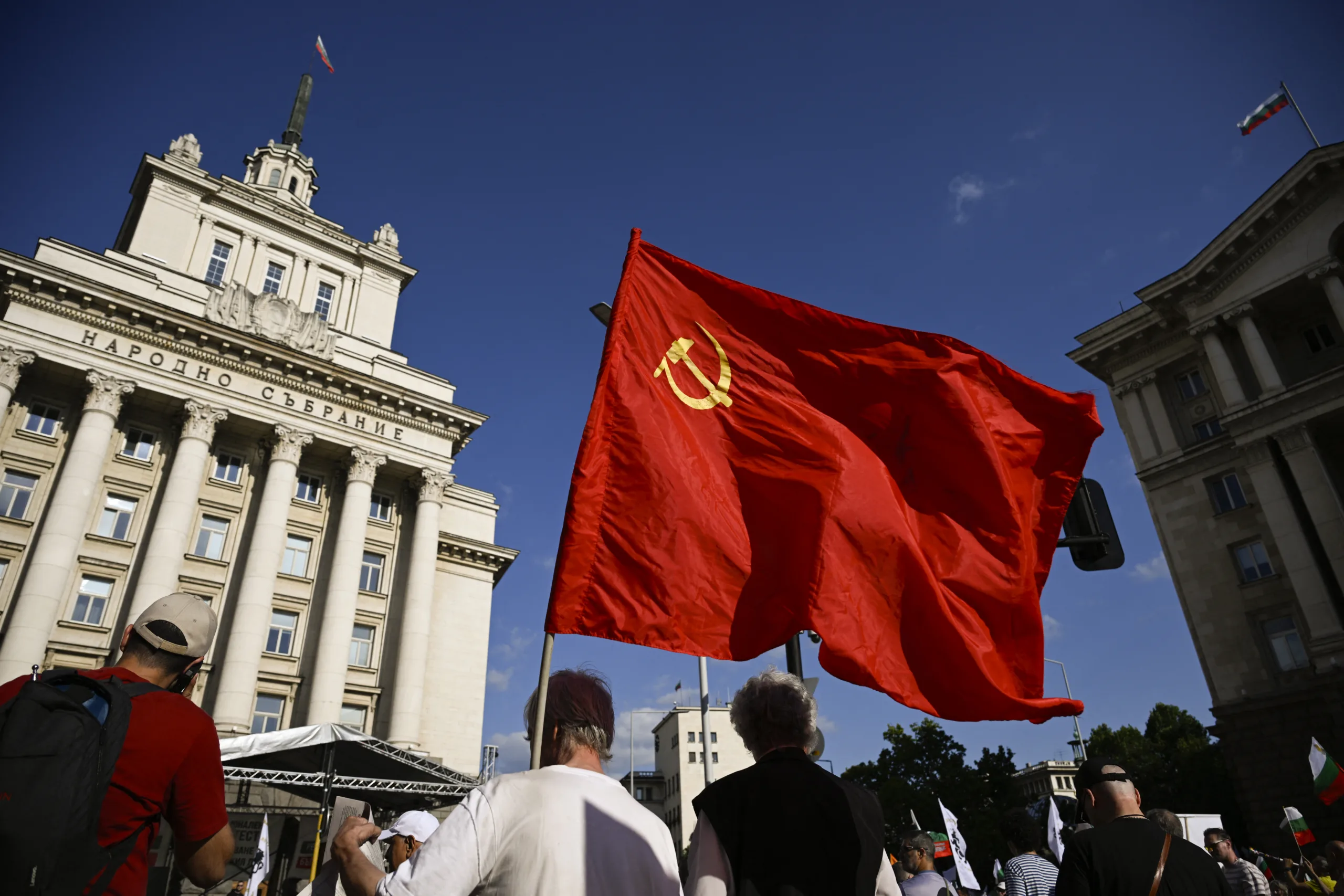 Um homem carrega uma bandeira da União Soviética durante uma manifestação contra a entrada da Bulgária na zona do euro, em Sófia, em 28 de junho de 2025.